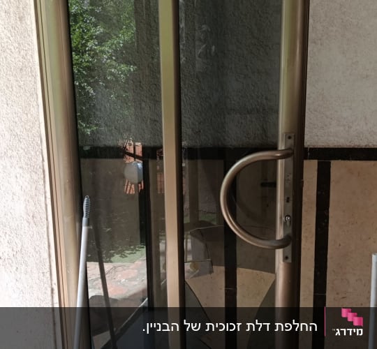 דלת זכוכית שבורה עם מטאטא ליד